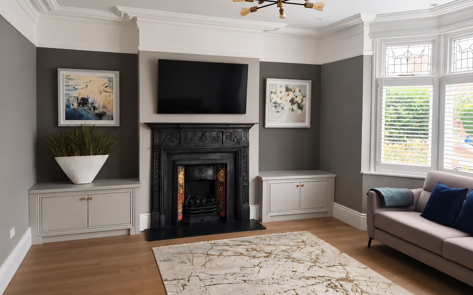Bespoke low alcove cabinets with panelled doors on either side of a traditional fireplace in a period living room.