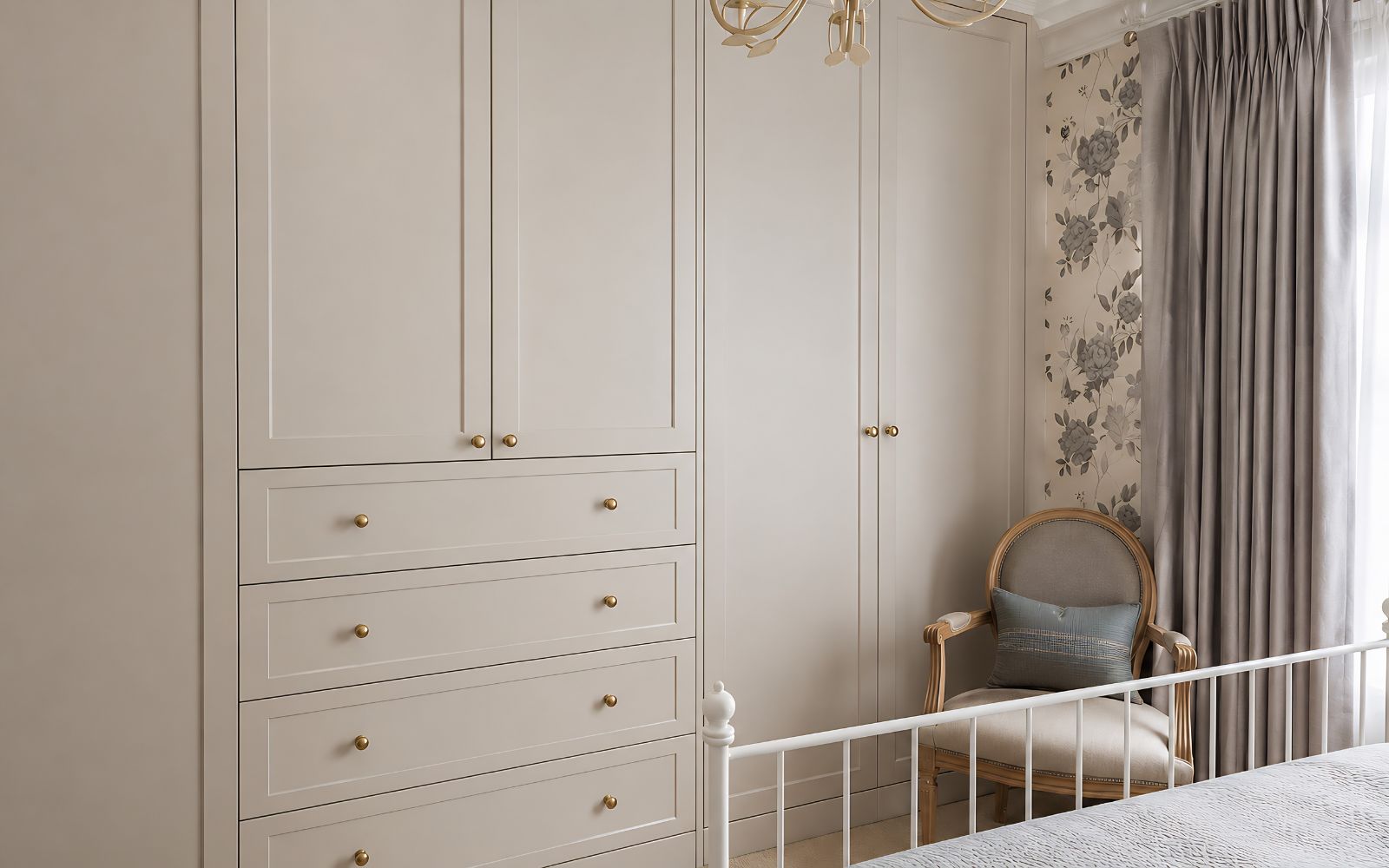 Bespoke fitted bedroom wardrobe with shaker-style doors, built-in drawers, brass knobs and a painted floor-to-ceiling finish.