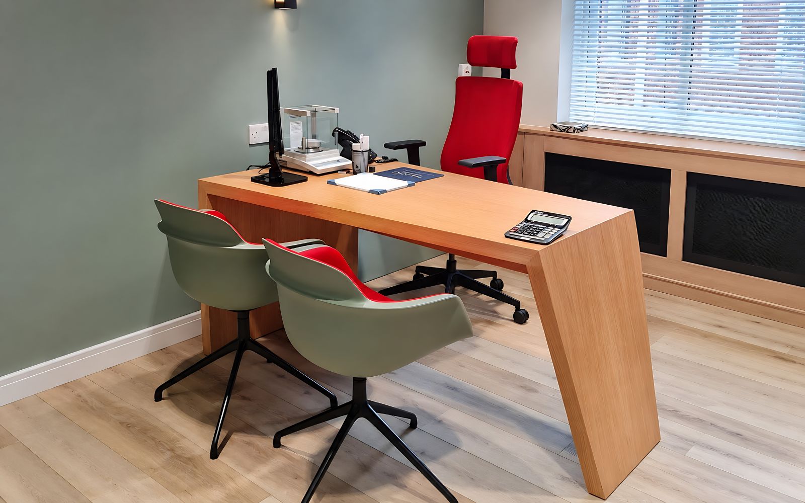 Modern bespoke office with timber desk, built-in storage and red office chair.